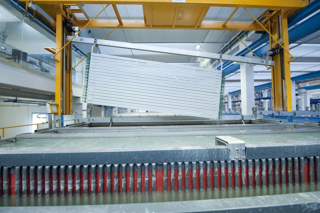 Wide interior view of a SAT AUTEL automatic anodizing plant with tanks and overhead cranes.