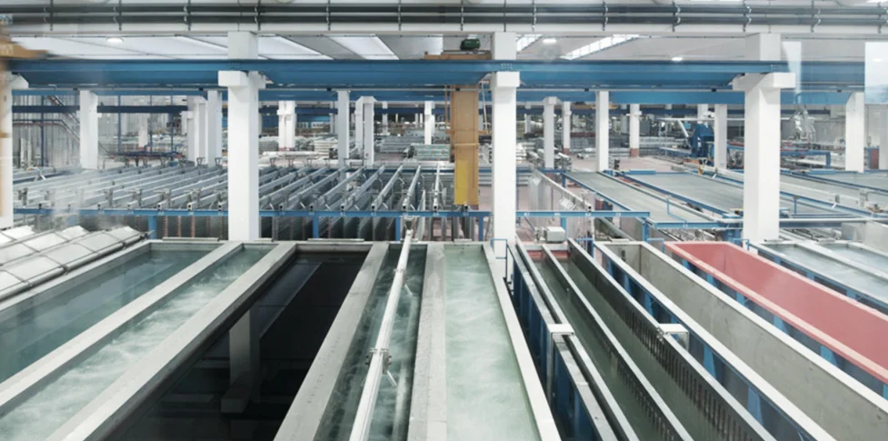 Conveyor and pretreatment tank line ahead of a SAT powder coating booth.