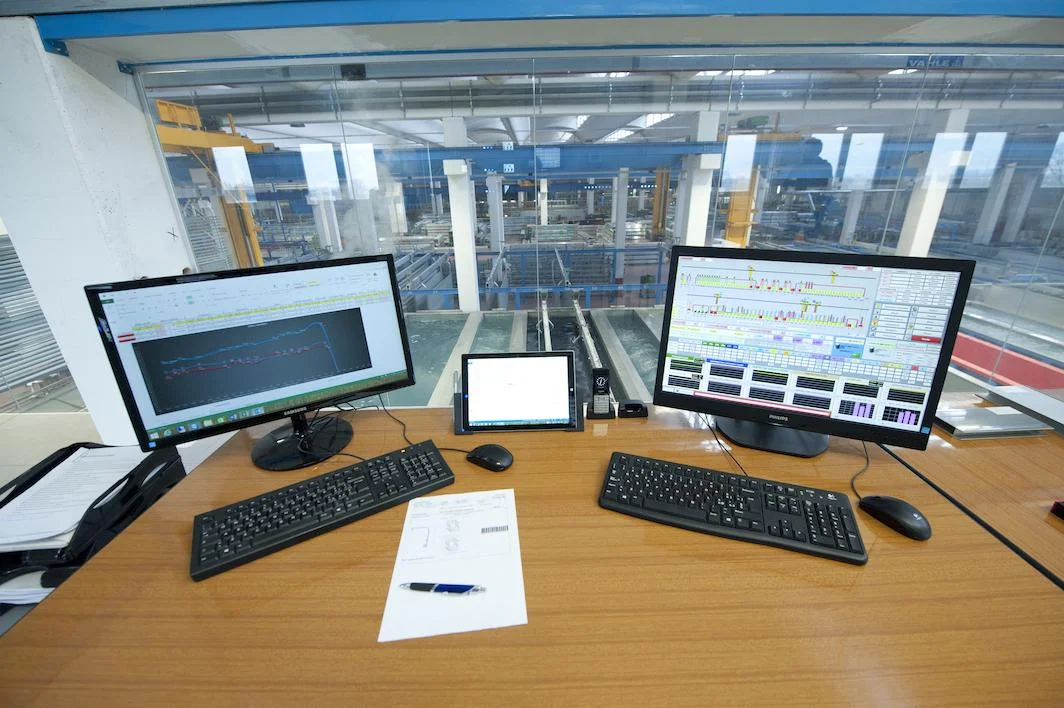 Operator adjusting controls on an AUTEL anodizing line control panel.