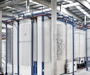 Interior of a SAT vertical powder coating booth with aluminum profiles suspended for coating.