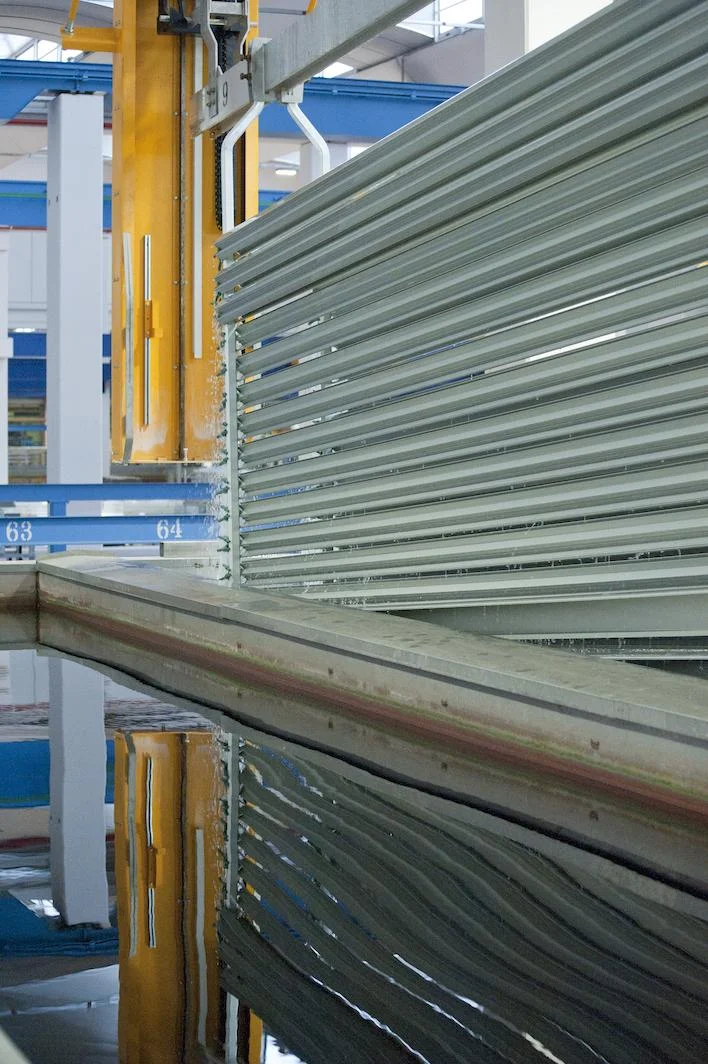 Close view of aluminum extrusion profiles racked for the anodizing process.